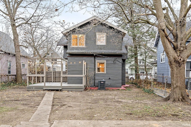 rear view of house with central AC unit and a wooden deck