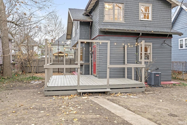 back of house with cooling unit and a deck