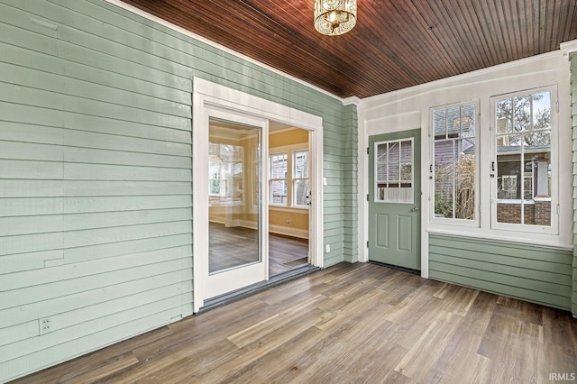 unfurnished sunroom with wooden ceiling and an inviting chandelier