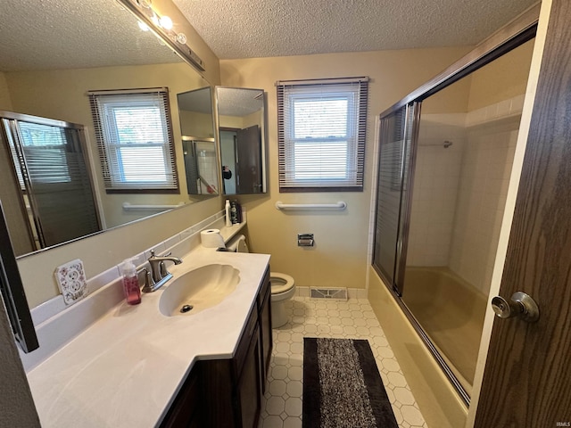 full bathroom with vanity, a textured ceiling, combined bath / shower with glass door, and plenty of natural light