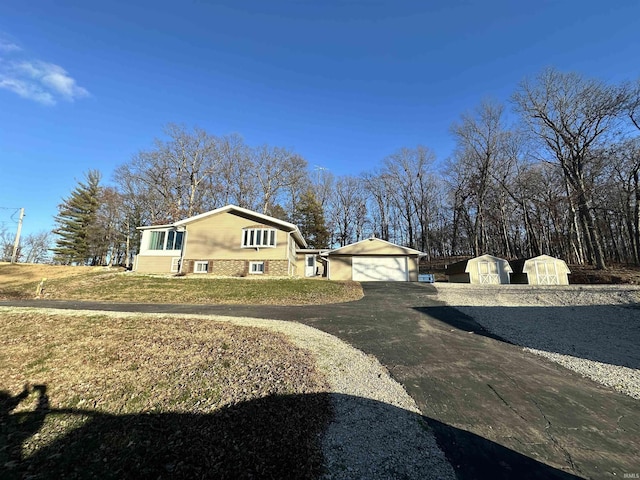 view of home's exterior with a yard, a garage, and a storage shed