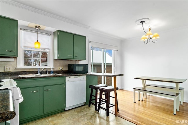 kitchen with backsplash, white appliances, light hardwood / wood-style flooring, a notable chandelier, and green cabinets