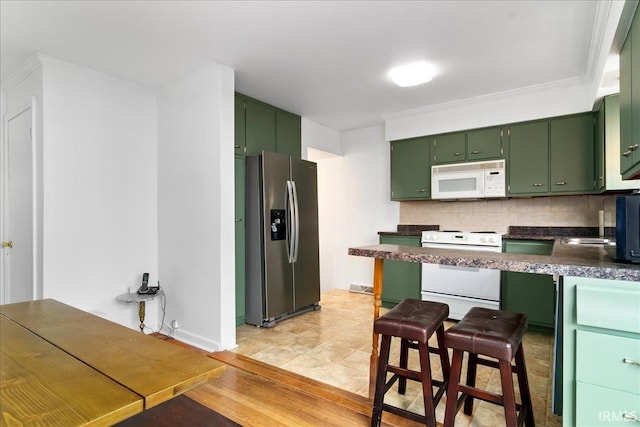 kitchen featuring tasteful backsplash, ornamental molding, white appliances, light hardwood / wood-style flooring, and green cabinets