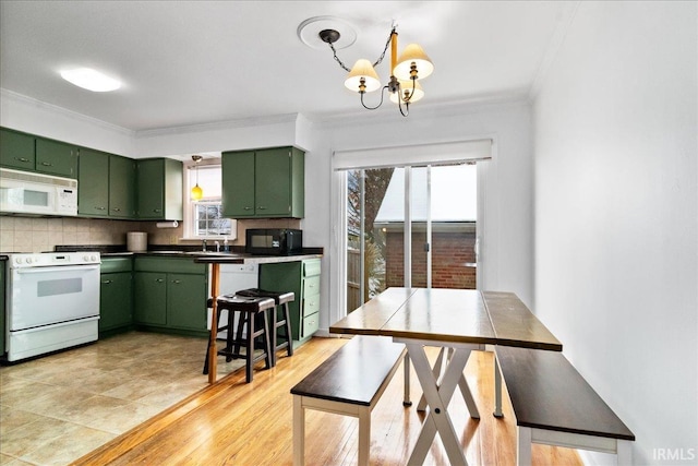 kitchen with light wood-type flooring, white appliances, green cabinetry, and a healthy amount of sunlight