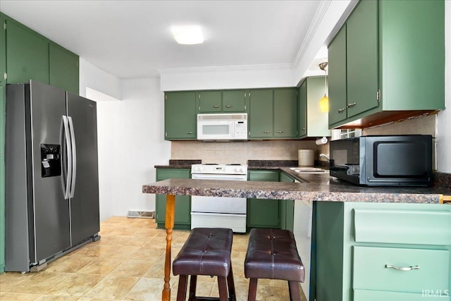 kitchen featuring decorative backsplash, crown molding, appliances with stainless steel finishes, and green cabinetry