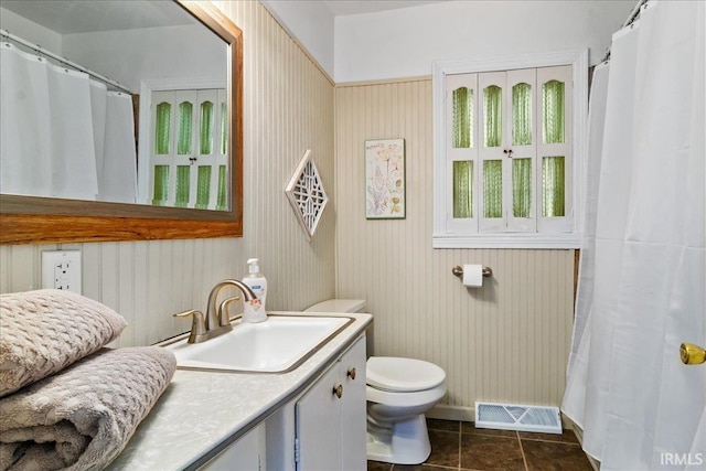 bathroom with tile patterned flooring, vanity, and toilet