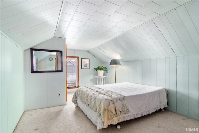 carpeted bedroom with vaulted ceiling and wooden walls