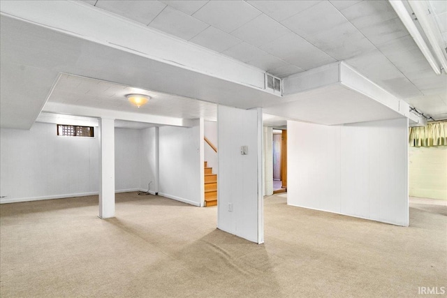 basement featuring light carpet