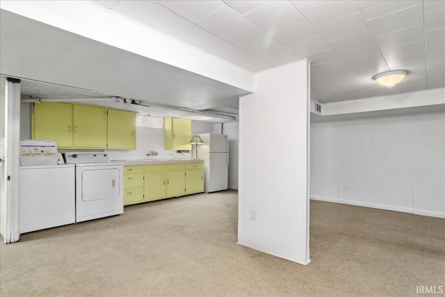 laundry room featuring light carpet, washer and clothes dryer, and cabinets