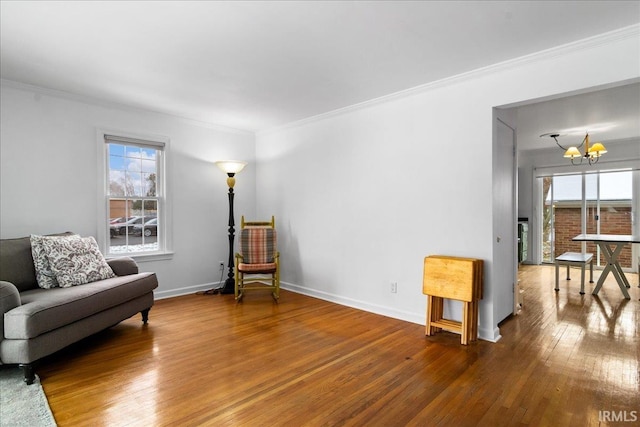 living area with a wealth of natural light, hardwood / wood-style floors, and crown molding