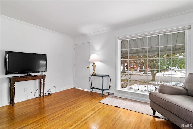 living area featuring crown molding and hardwood / wood-style flooring