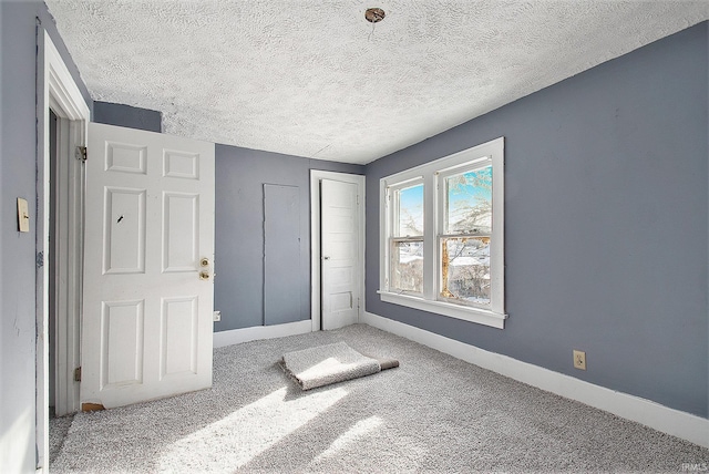 unfurnished bedroom with carpet flooring and a textured ceiling