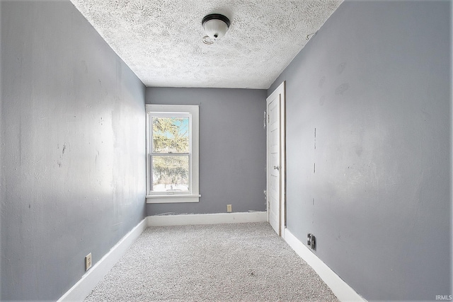 carpeted empty room featuring a textured ceiling