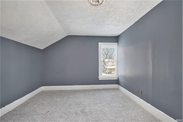 additional living space with a textured ceiling, carpet floors, and vaulted ceiling