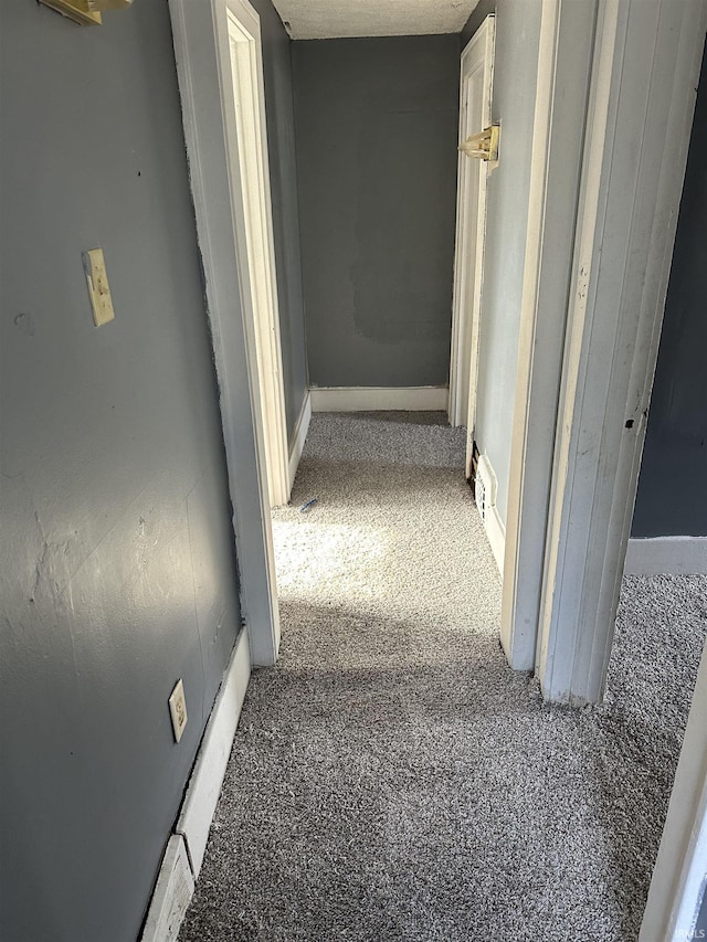 hallway featuring dark carpet