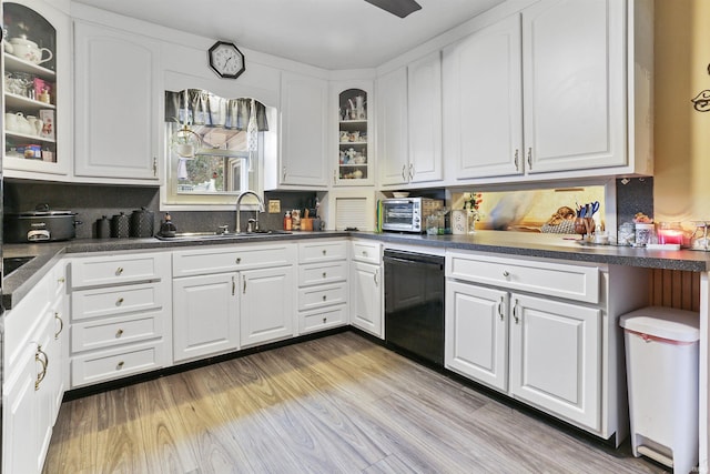 kitchen featuring sink, light hardwood / wood-style flooring, white cabinets, and black dishwasher