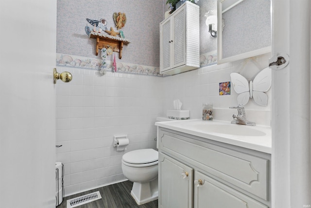 bathroom with vanity, tile walls, and toilet