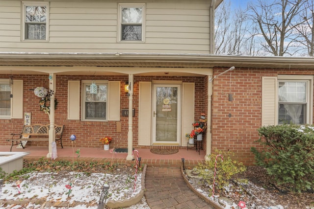 snow covered property entrance featuring a porch