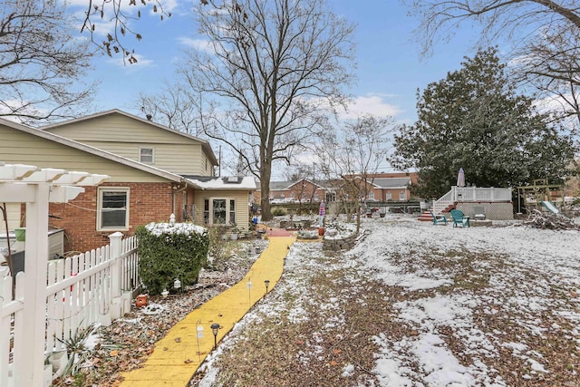 yard covered in snow with a pergola