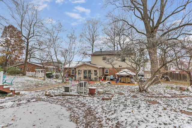 view of snow covered back of property