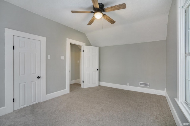 interior space featuring light carpet, vaulted ceiling, and ceiling fan