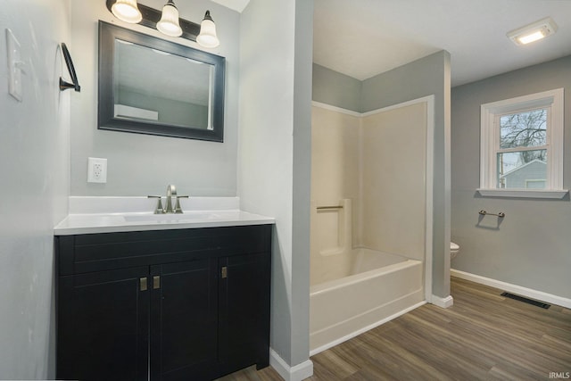 full bathroom featuring toilet, vanity,  shower combination, and hardwood / wood-style flooring