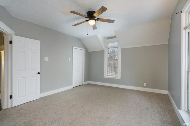 bonus room with light carpet, a textured ceiling, ceiling fan, and lofted ceiling