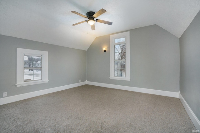 additional living space featuring ceiling fan, carpet, and lofted ceiling