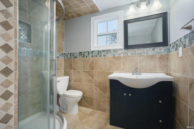 bathroom with vanity, tile patterned floors, toilet, tile walls, and walk in shower