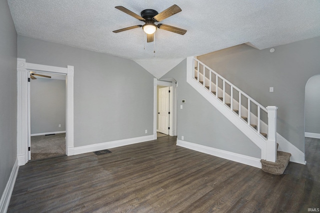 unfurnished living room with ceiling fan, dark wood-type flooring, and a textured ceiling