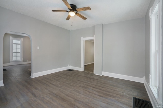 empty room featuring a textured ceiling, dark hardwood / wood-style floors, and ceiling fan