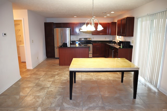 kitchen with appliances with stainless steel finishes, sink, decorative light fixtures, a chandelier, and a center island