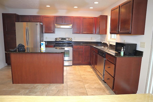 kitchen featuring a center island, sink, appliances with stainless steel finishes, and dark stone counters