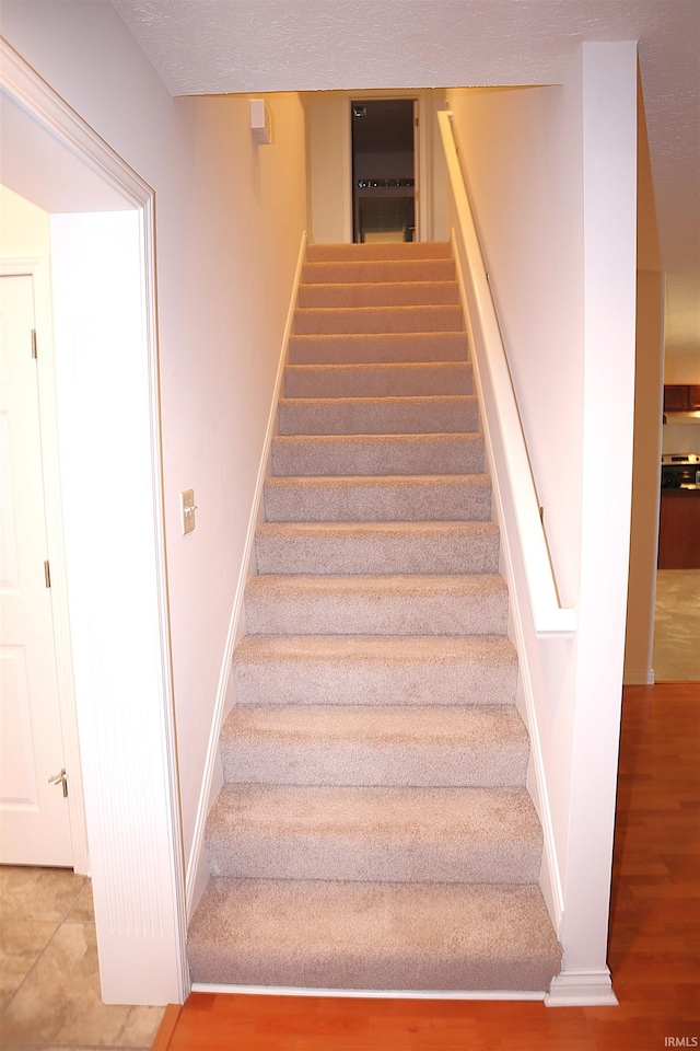 staircase with hardwood / wood-style flooring