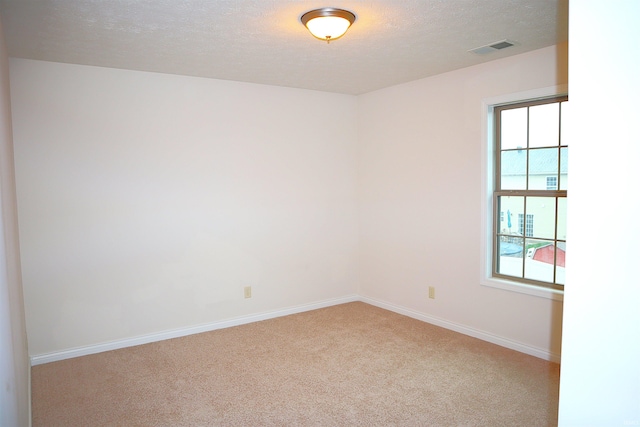 carpeted spare room with a textured ceiling