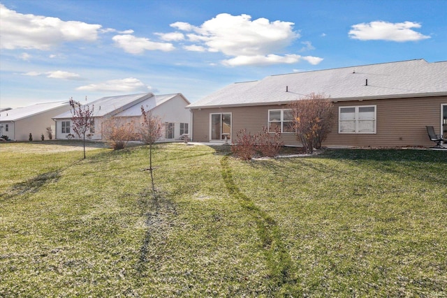 rear view of house featuring a lawn