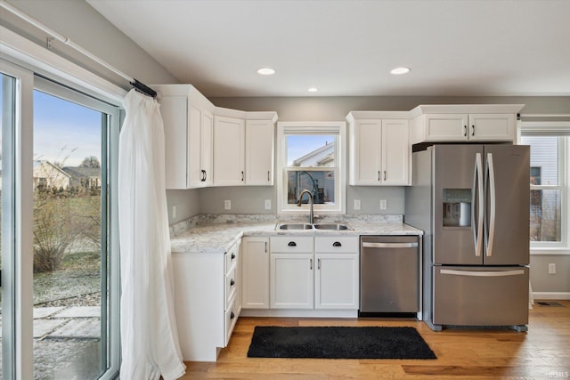 kitchen featuring stainless steel appliances, a wealth of natural light, and sink