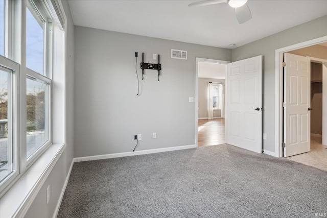 carpeted spare room featuring ceiling fan