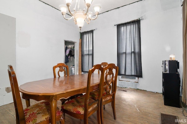 dining area featuring hardwood / wood-style flooring and a chandelier