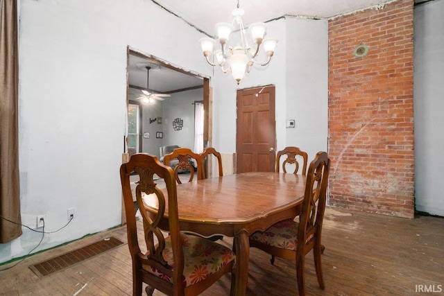 dining room featuring hardwood / wood-style floors, ceiling fan with notable chandelier, and brick wall