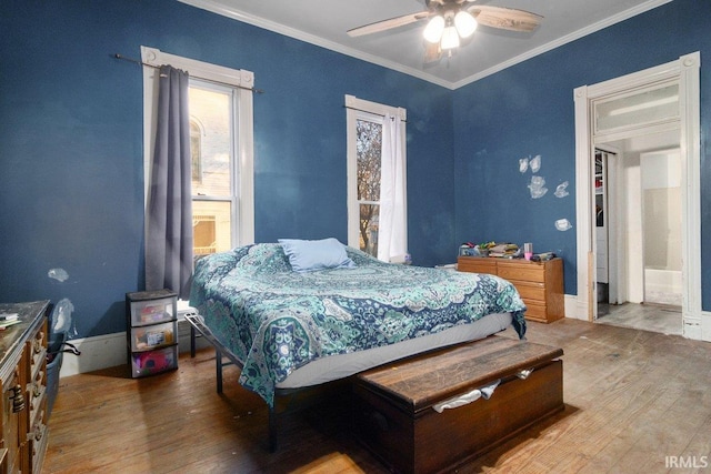 bedroom with wood-type flooring, ensuite bath, ceiling fan, and ornamental molding