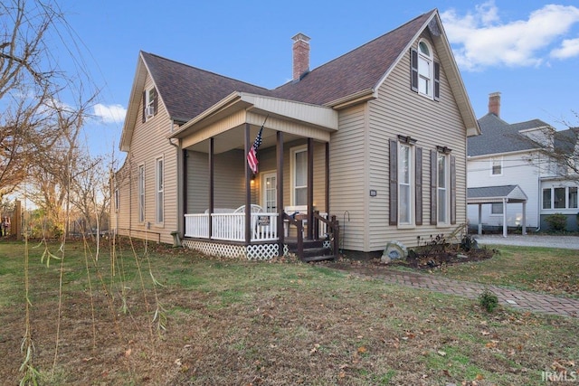 view of front of house featuring covered porch and a front lawn