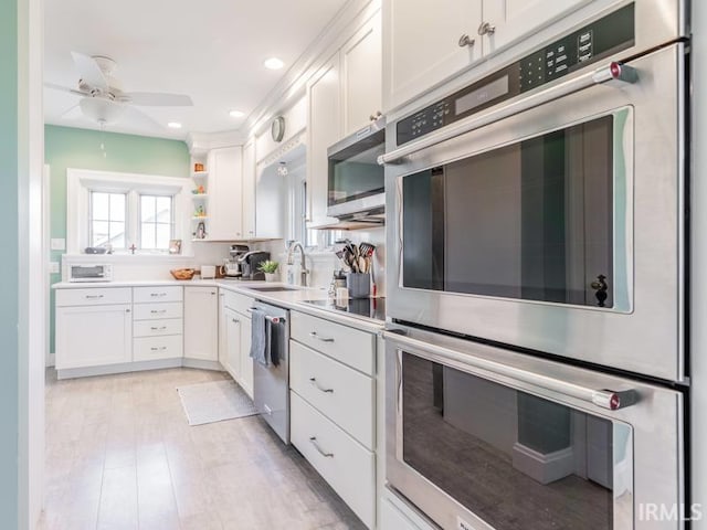 kitchen featuring stainless steel appliances, white cabinetry, ceiling fan, and sink