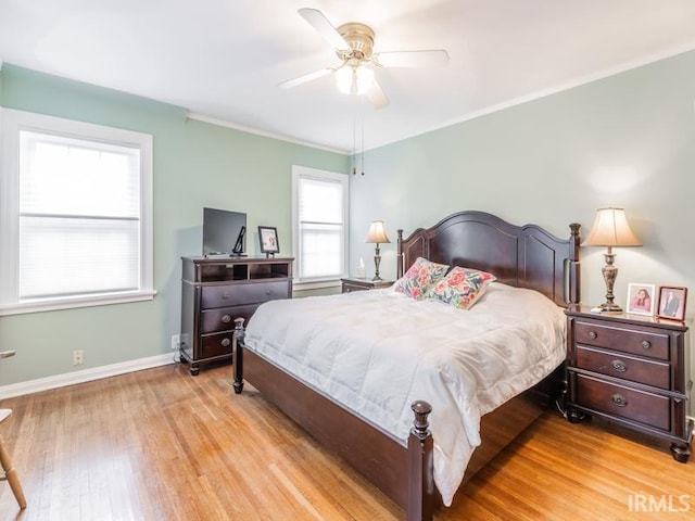 bedroom with ceiling fan, light wood-type flooring, and crown molding