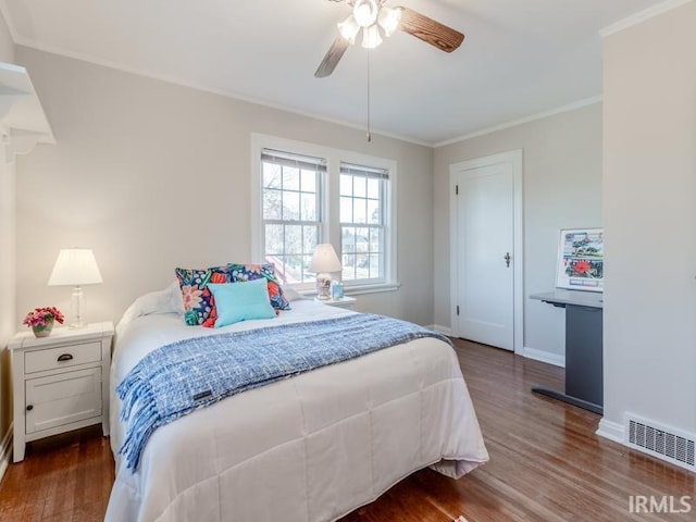 bedroom featuring ceiling fan, dark hardwood / wood-style flooring, and crown molding