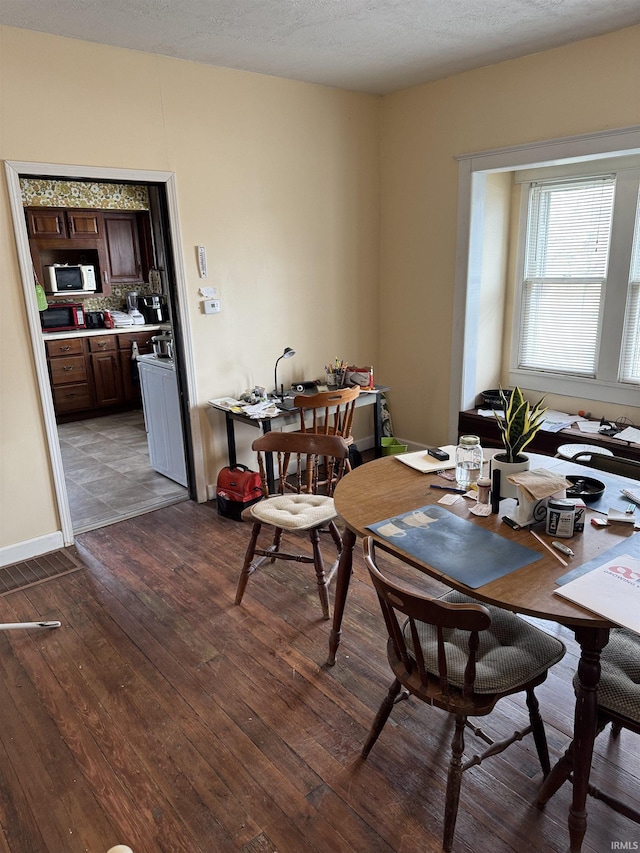 dining space with light hardwood / wood-style floors and a textured ceiling