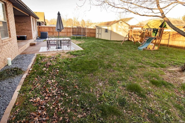 view of yard with central AC, a trampoline, a playground, a shed, and a patio