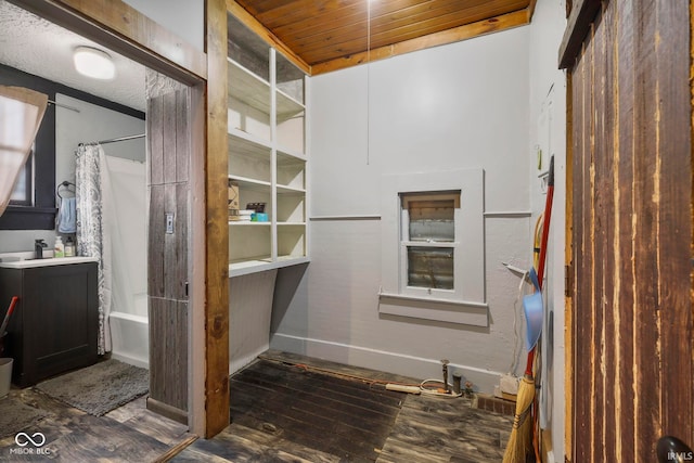 bathroom featuring hardwood / wood-style floors, wooden ceiling, shower / tub combo, and sink