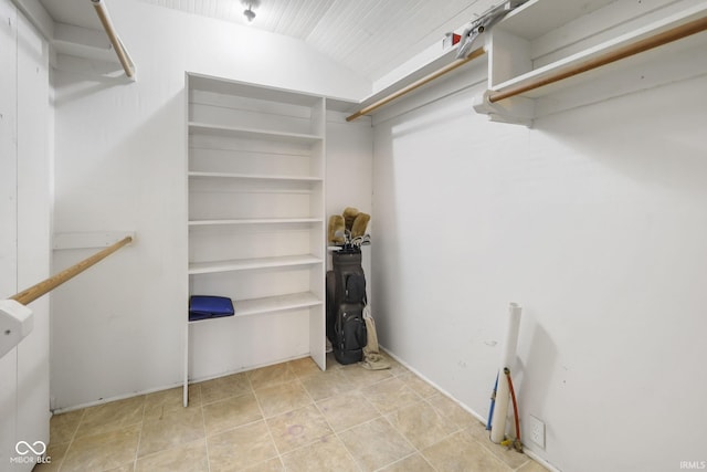 spacious closet featuring light tile patterned flooring and vaulted ceiling