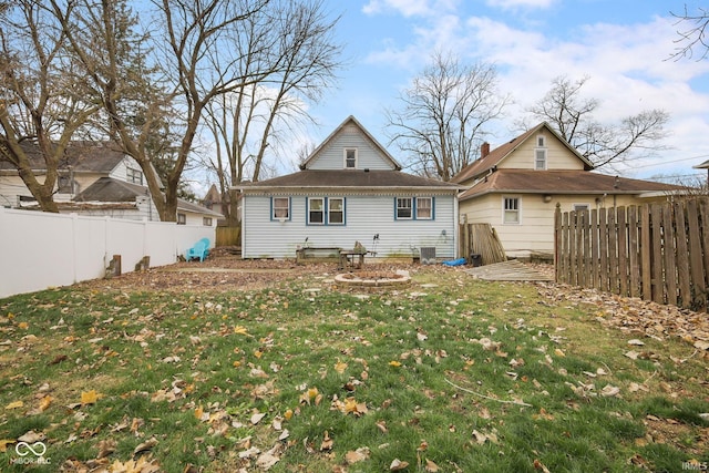 rear view of property featuring a lawn